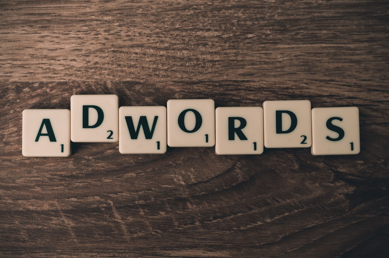 Wood grain background with scrabble letters spelling out "ADWORDS"